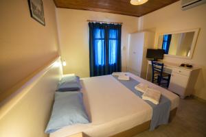 a bedroom with a large bed with blue pillows at Sunset Hotel in Agios Ioannis Kaspaka
