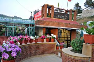 a flower shop with potted plants on a brick wall at Hotel Shiva Continental in Mussoorie