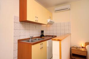 a small kitchen with a sink and a refrigerator at Apartments and rooms with parking space Jelsa, Hvar - 8798 in Jelsa