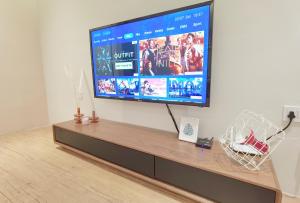 una grande TV a schermo piatto seduta sopra un centro di intrattenimento di The Toorak @ Bangsar South Mid Valley a Kuala Lumpur Altre 27 foto
