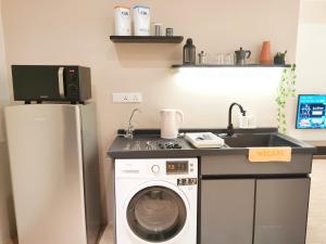 una cucina con lavatrice e lavandino di The Toorak @ Bangsar South Mid Valley a Kuala Lumpur