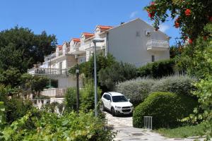 une voiture blanche garée devant un bâtiment dans l'établissement Apartments with a parking space Mlini, Dubrovnik - 8834, à Mlini