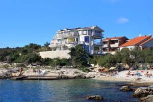 a large building on a beach next to the water at Apartment Zecevo Rtic 8366d in Rogoznica