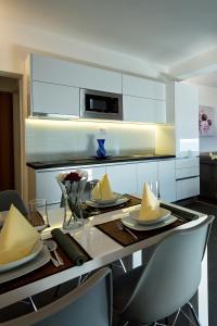 a kitchen with a table with plates and napkins on it at Apartment Zecevo Rtic 8366d in Rogoznica