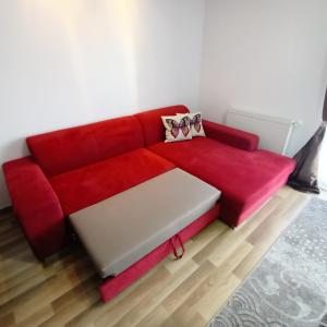 a red couch sitting in a living room at Apartament Ovidiu in Giroc