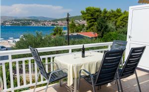 einen Tisch und Stühle auf einem Balkon mit Blick auf das Wasser in der Unterkunft Apartment Okrug Gornji 8440c in Trogir