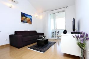 a living room with a couch and a tv at Apartments by the sea Zecevo Rtic, Rogoznica - 10333 in Rogoznica