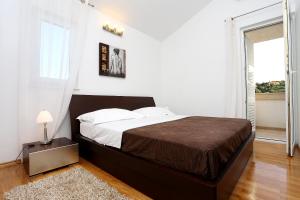 a bedroom with a large bed and a window at Apartments by the sea Zecevo Rtic, Rogoznica - 10333 in Rogoznica