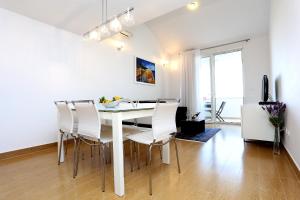 a white dining room with a white table and chairs at Apartments by the sea Zecevo Rtic, Rogoznica - 10333 in Rogoznica
