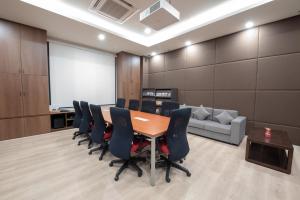 a conference room with a table and chairs and a couch at GRANFERTE Phnom Penh Hotel in Phnom Penh