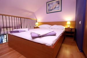 una camera da letto con un grande letto con asciugamani viola di Apartments by the sea Zecevo Rtic, Rogoznica - 10334 a Rogoznica (Rogosnizza)