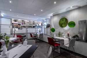 a restaurant with white tables and red chairs at Hotel Stadt Heidelberg in Darmstadt