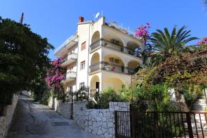 um edifício branco com varandas numa rua em Rooms by the sea Mavarstica, Ciovo - 10335 em Trogir