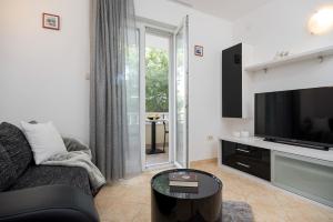 a living room with a couch and a television at Apartments and rooms with parking space Rogoznica - 10339 in Rogoznica