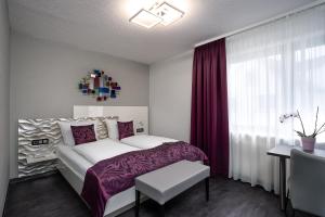 a bedroom with a bed with purple sheets and a window at Hotel Stadt Heidelberg in Darmstadt +39 photos