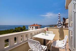 a white table and chairs on a balcony with the ocean at Apartments and rooms with parking space Rogoznica - 10339 in Rogoznica