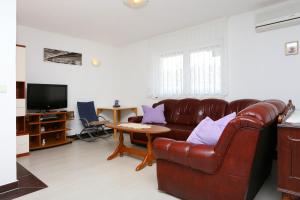 a living room with a leather couch and a table at Apartments with a parking space Omis - 10349 in Omiš