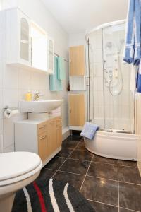 a bathroom with a sink and a shower and a toilet at Apartments with a parking space Omis - 10349 in Omiš