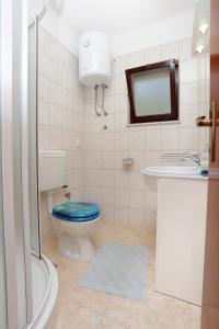 ein Badezimmer mit einem WC, einem Waschbecken und einem Spiegel in der Unterkunft Apartments by the sea Drvenik Veliki, Drvenik - 10346 in Drvenik Veli