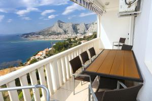 a balcony with a table and chairs overlooking the ocean at Apartments with a parking space Omis - 10349 in Omiš