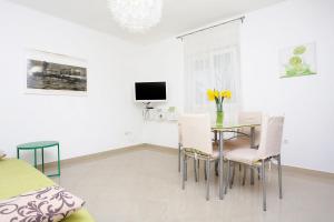 ein Esszimmer mit einem Tisch und Stühlen sowie einem TV in der Unterkunft Apartments with a parking space Omis - 10351 in Omiš