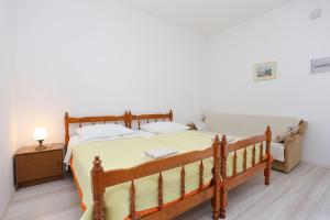 ein Schlafzimmer mit einem großen Holzbett mit gelber Bettwäsche in der Unterkunft Apartments with a parking space Omis - 10351 in Omiš