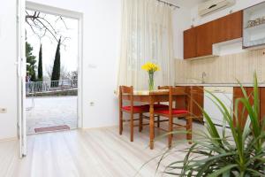eine Küche mit einem Tisch und Stühlen sowie einen Balkon in der Unterkunft Apartments with a parking space Omis - 10351 in Omiš