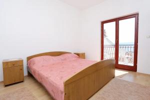 1 dormitorio con cama y ventana grande en Apartments with a parking space Lokva Rogoznica, Omis - 10358 en Lokva Rogoznica