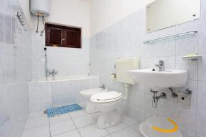 een witte badkamer met een toilet en een wastafel bij Apartments with a parking space Lokva Rogoznica, Omis - 10358 in Lokva Rogoznica