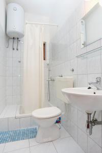 een witte badkamer met een toilet en een wastafel bij Apartments with a parking space Lokva Rogoznica, Omis - 10358 in Lokva Rogoznica