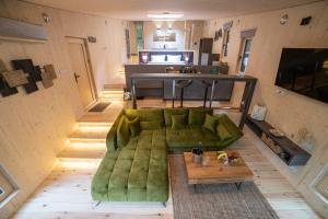 a living room with a green couch and a table at Nomád Glamping in Noszvaj