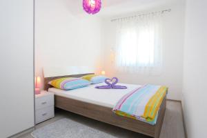 Un dormitorio con una cama con una cinta morada. en Apartments with a parking space Omis - 10362, en Omiš