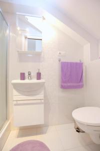 Baño blanco con lavabo y aseo en Apartments with a parking space Omis - 10362, en Omiš