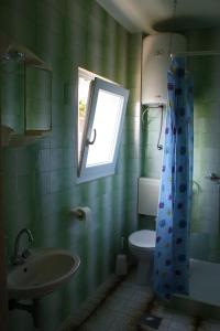 a bathroom with a sink and a toilet and a window at Apartments with parking space Stanici, Omis - 10360 in Celina