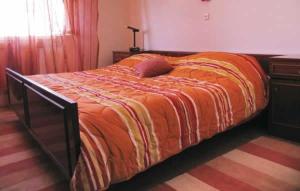 a bed with an orange comforter in a bedroom at Seaside holiday house Brna, Korcula - 11038 in Smokvica