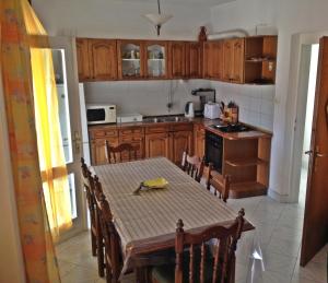 a kitchen with a table and chairs and a kitchen with wooden cabinets at Seaside holiday house Brna, Korcula - 11038 in Smokvica