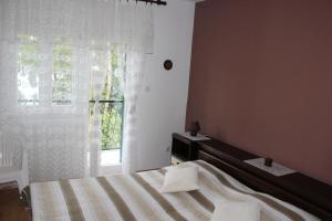Schlafzimmer mit einem Bett und einem Fenster in der Unterkunft Apartments by the sea Arbanija, Ciovo - 11041 in Trogir