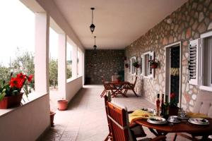 un patio con mesa y sillas en una pared de piedra en Holiday house with a swimming pool Bol, Brac - 11016, en Bol