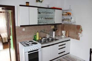 eine kleine Küche mit einer Spüle und einem Herd in der Unterkunft Apartments by the sea Arbanija, Ciovo - 11041 in Trogir