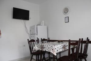 ein Esszimmer mit einem Tisch und einem Kühlschrank in der Unterkunft Apartments by the sea Arbanija, Ciovo - 11041 in Trogir