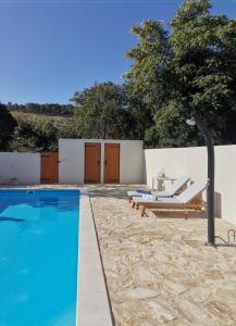 een zwembad met 2 lounges en een tafel en stoelen bij Holiday house with a swimming pool Vrbanj, Hvar - 11040 in Vrbanj
