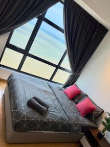 a bed in a room with a large window at IMPERIUM RESIDENCE KUANTAN [Seaview] Family Suite in Kuantan