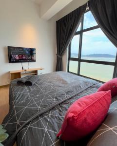 a bedroom with a large bed with a large window at IMPERIUM RESIDENCE KUANTAN [Seaview] Family Suite in Kuantan