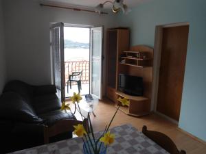 ein Wohnzimmer mit einem Sofa und einem Tisch mit Blumen in der Unterkunft Apartments by the sea Sobra, Mljet - 11011 in Sobra