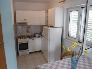 a kitchen with white cabinets and a white refrigerator at Apartments by the sea Sobra, Mljet - 11011 in Sobra