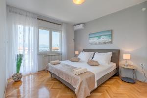 a bedroom with a large bed and a large window at Apartments by the sea Slatine, Ciovo - 11047 in Slatine