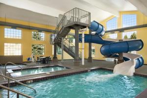 a swimming pool with a water slide in a building at Ramada by Wyndham Spokane Airport in Spokane