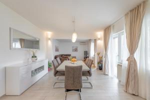 ein Esszimmer und eine Küche mit einem Tisch und Stühlen in der Unterkunft Apartments by the sea Slatine, Ciovo - 11047 in Slatine
