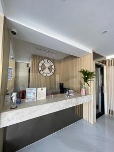 a lobby with a counter with a clock on the wall at Hotel Simone Kalibo in Kalibo