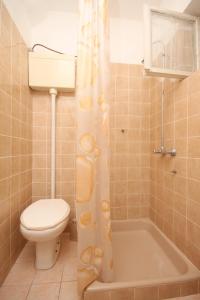 a bathroom with a toilet and a shower curtain at Apartments by the sea Drvenik Donja vala, Makarska - 11083 in Drvenik